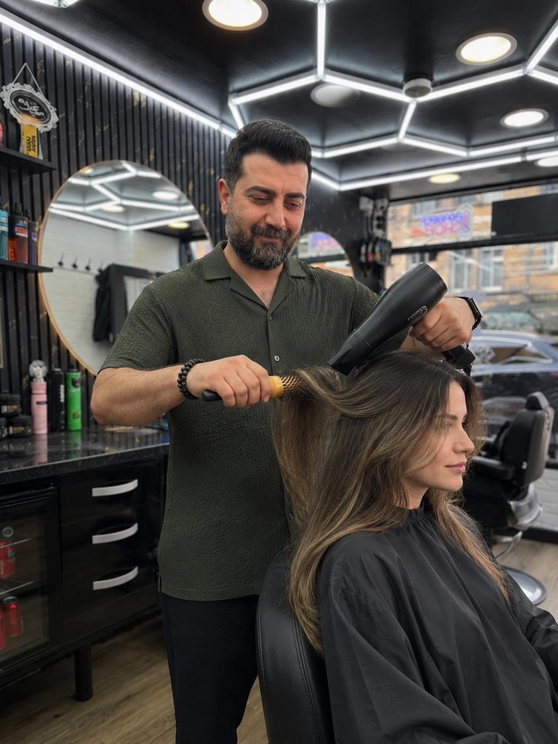Mehmet blow-drying a client's hair at Red Hair Salon